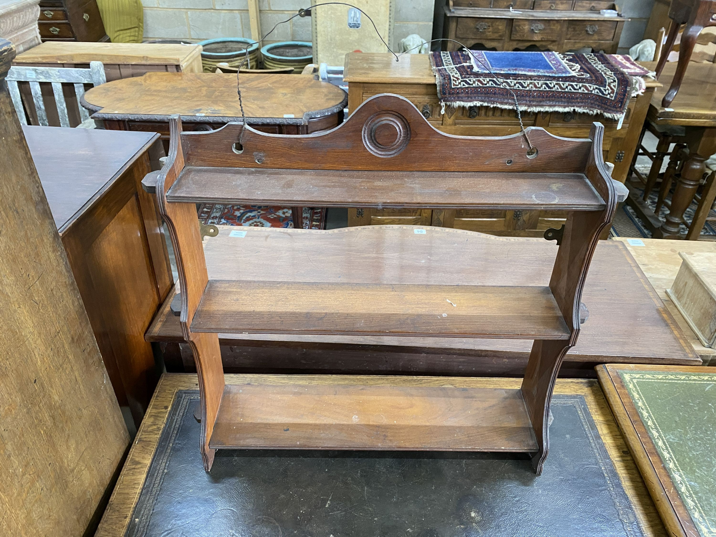 An Edwardian rosewood and marquetry inlaid bow front writing table, width 91cm, depth 49cm, height 72cm and a Victorian walnut three tier wall bracket